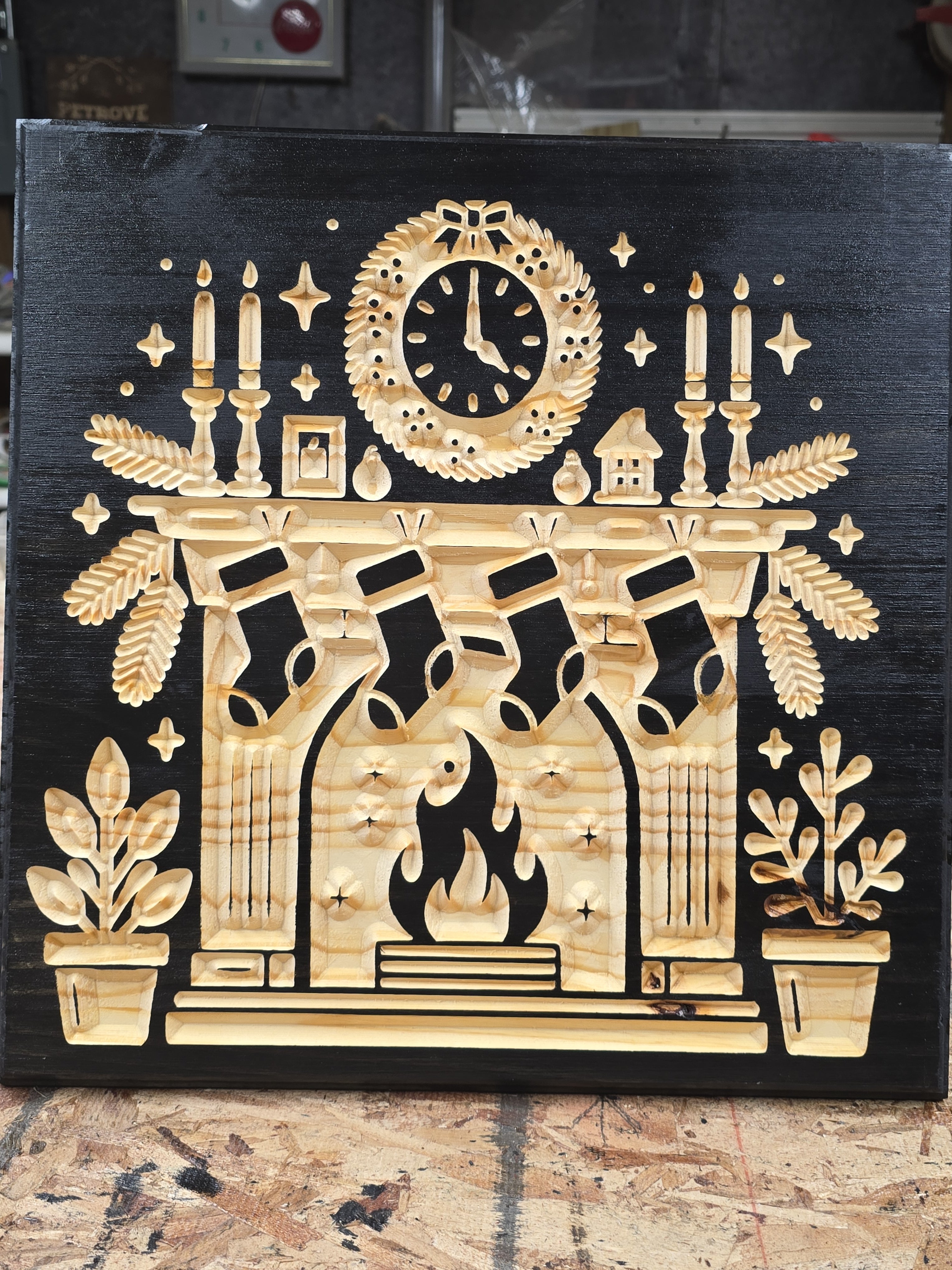 Decorative Christmas fireplace wooden panel with intricate carvings on a black background