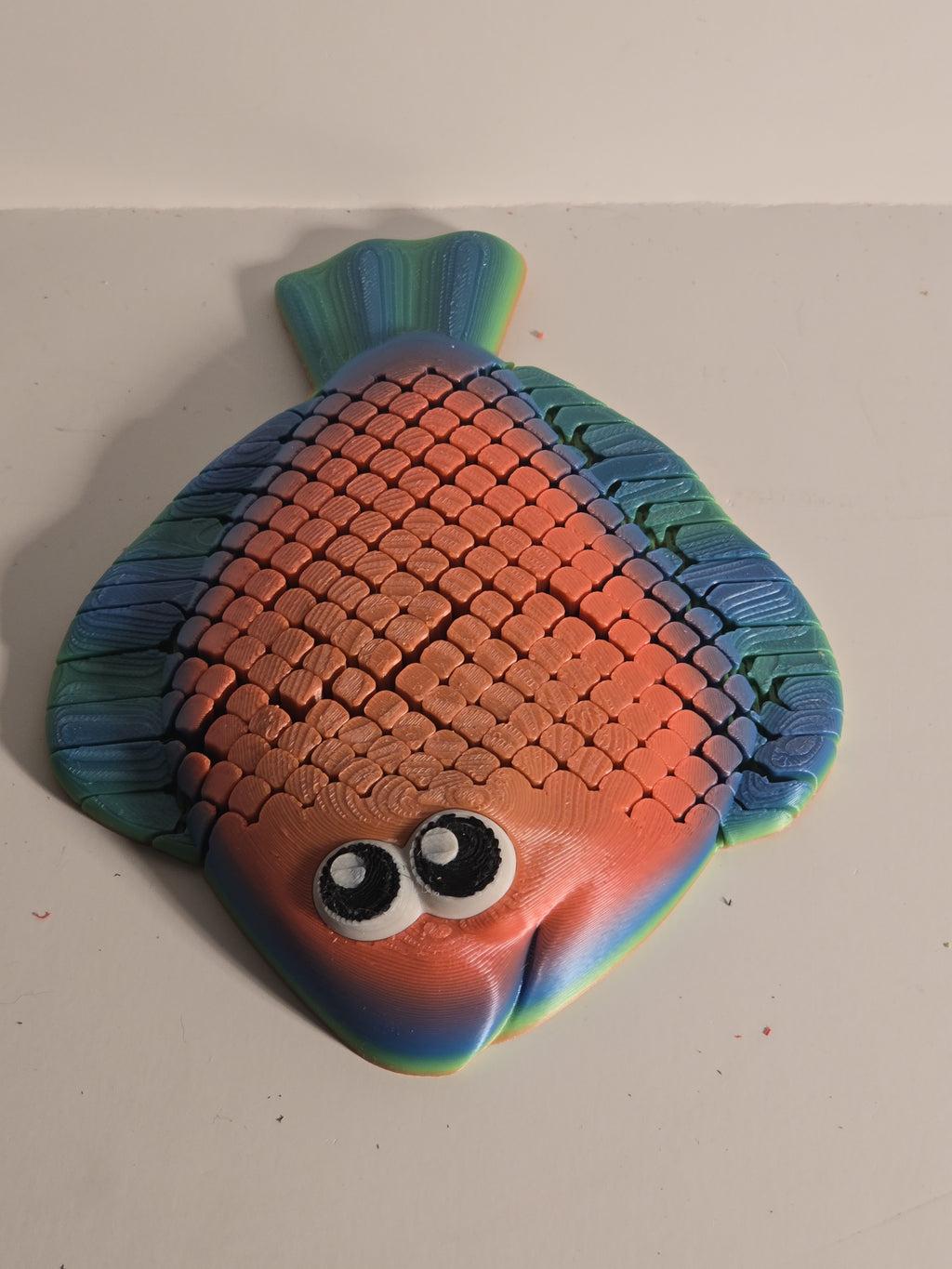 Colorful fish-shaped object on a plain background