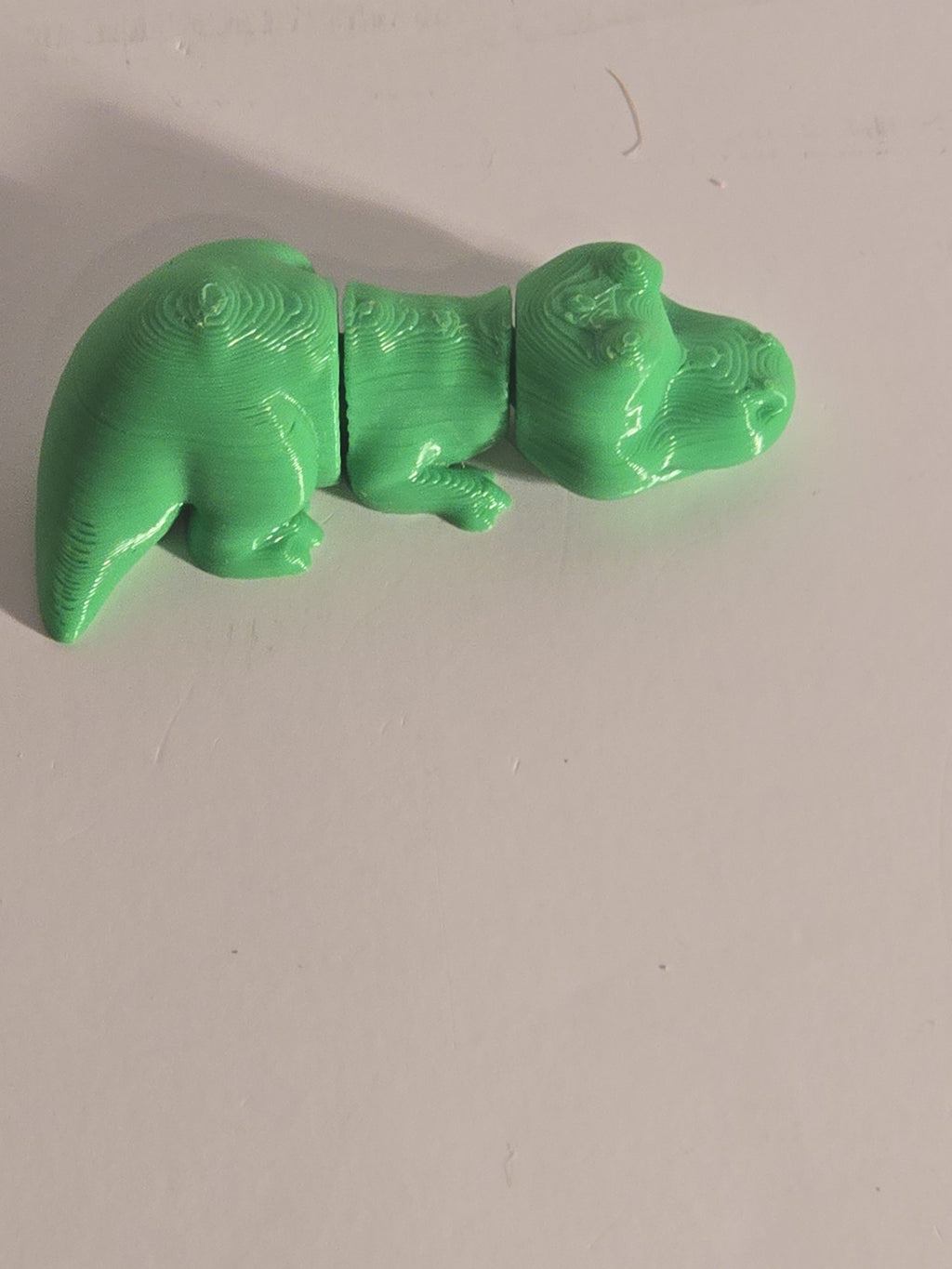 Green ceramic object resembling a bear on a white background