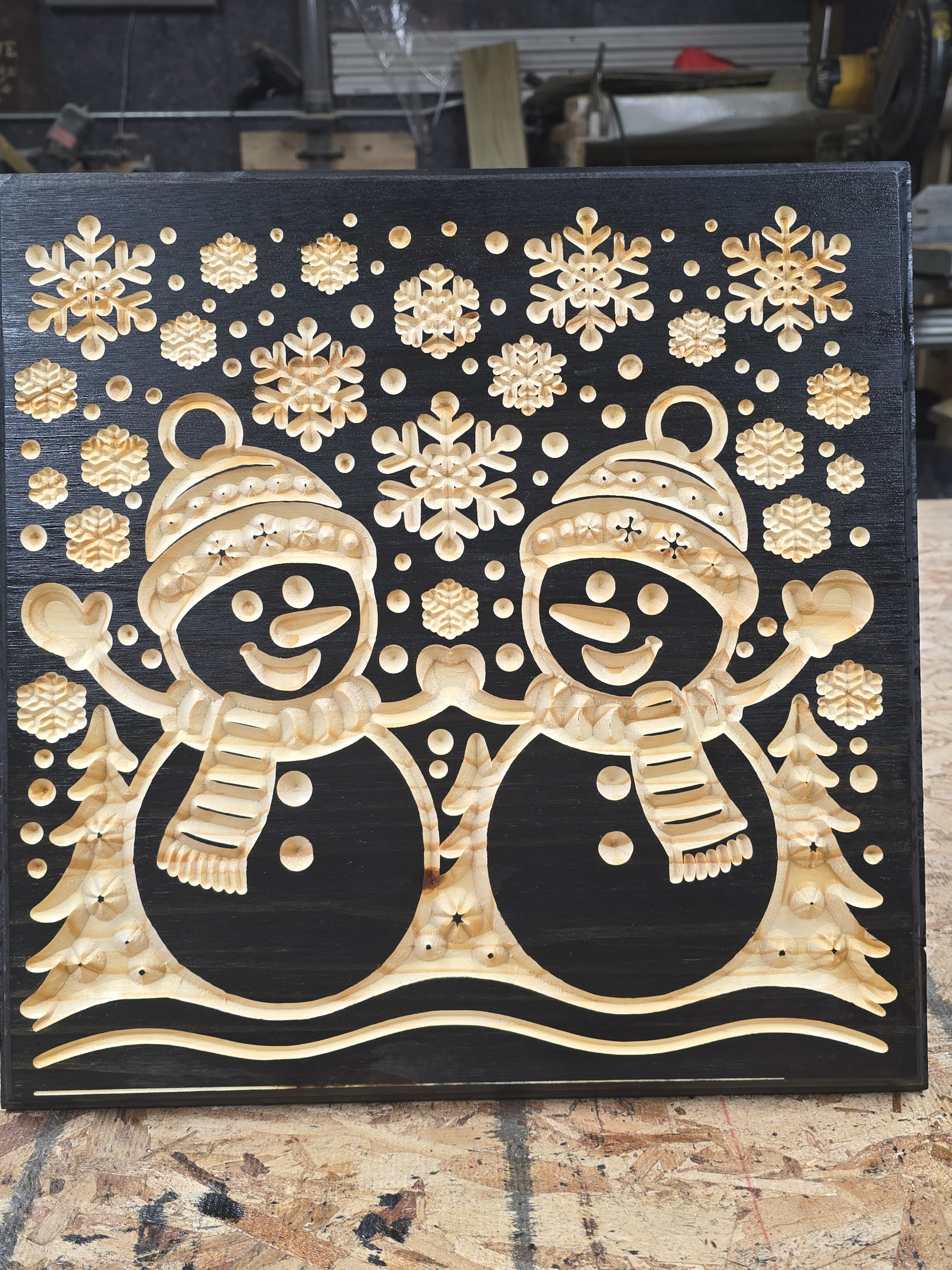 Decorative wall art with snowmen and snowflakes on a black background